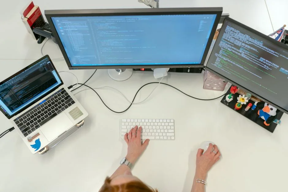 A stylish workspace featuring a laptop and monitors displaying design software.